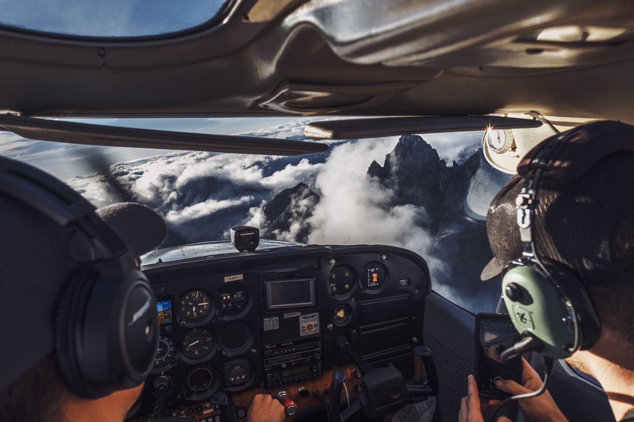 Pilots perspective of flying over clouds and mountains, capturing the breathtaking view.